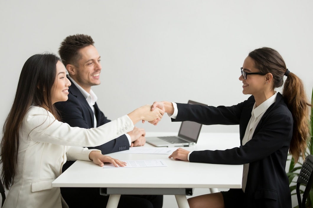smiling diverse businesswomen shake hands group meeting deal concept